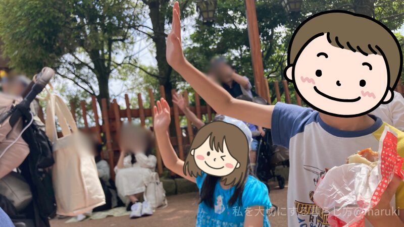 昼のパレードでキャラクターに手を振る子どもたち