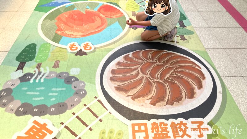 郡山駅に描かれていた福島名産品と一緒に記念撮影