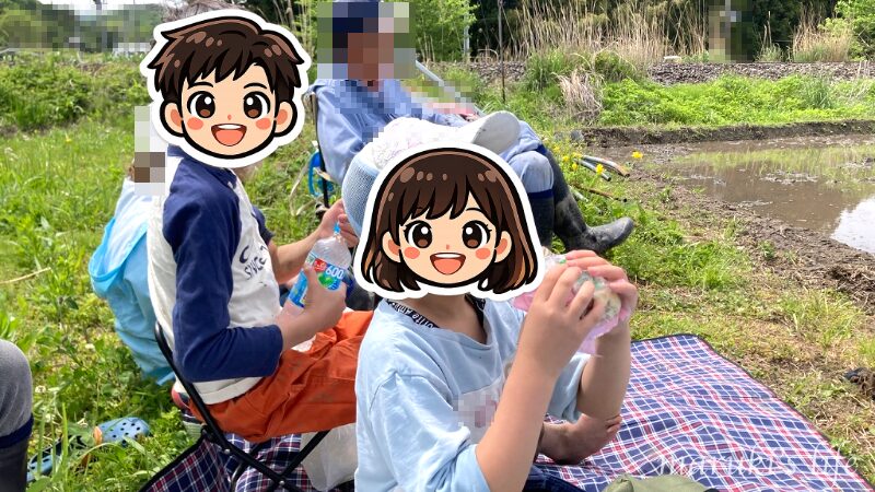 田んぼの脇でシートを広げてお昼ご飯を食べる
